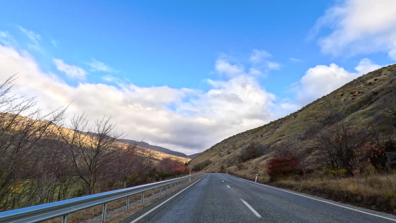 A 12-second drive through Wanaka's stunning mountainous terrain under a bright blue sky with scattered clouds