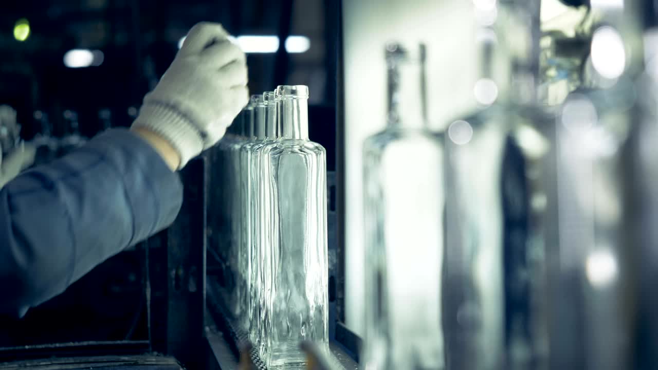 el trabajador del invernadero está midiendo los cuellos de las botellas y eliminando las botellas defectuosas