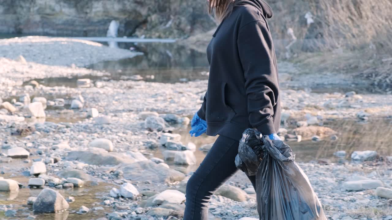 Lavoro di squadra per la pulizia della plastica sulla spiaggia. Volontari raccolgono rifiuti in un sacco della spazzatura. Concetto di inquinamento da plastica e problema ambientale. Pulizia volontaria della natura dalla plastica. Rendere il pianeta più verde.