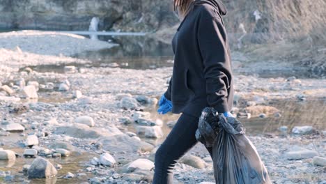 teamwork cleaning plastic on the beach. volunteers collect trash in a trash bag. plastic pollution and environmental problem concept. voluntary cleaning of nature from plastic. greening the planet