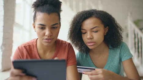 two women shopping online with tablet and credit card