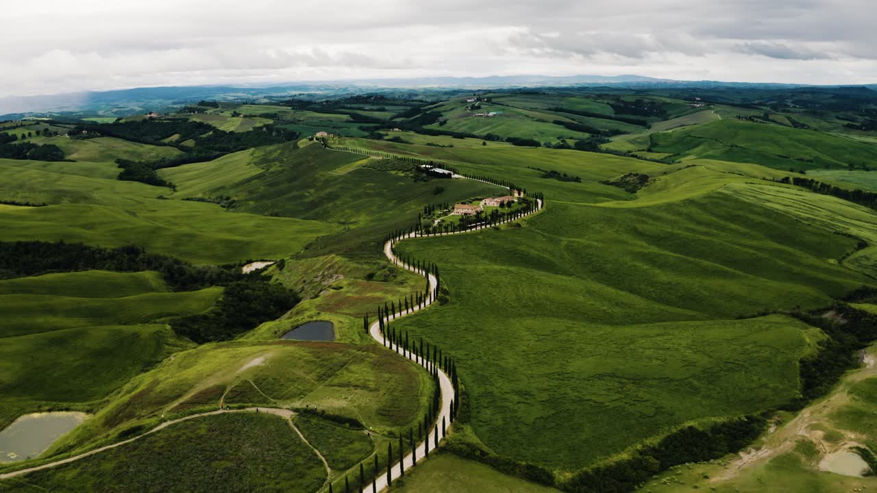 fotografía de un avión no tripulado de un camino sinuoso que conduce a una granja en la toscana, italia