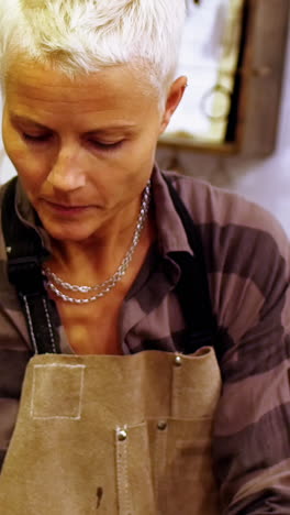 craftswoman making leather belt