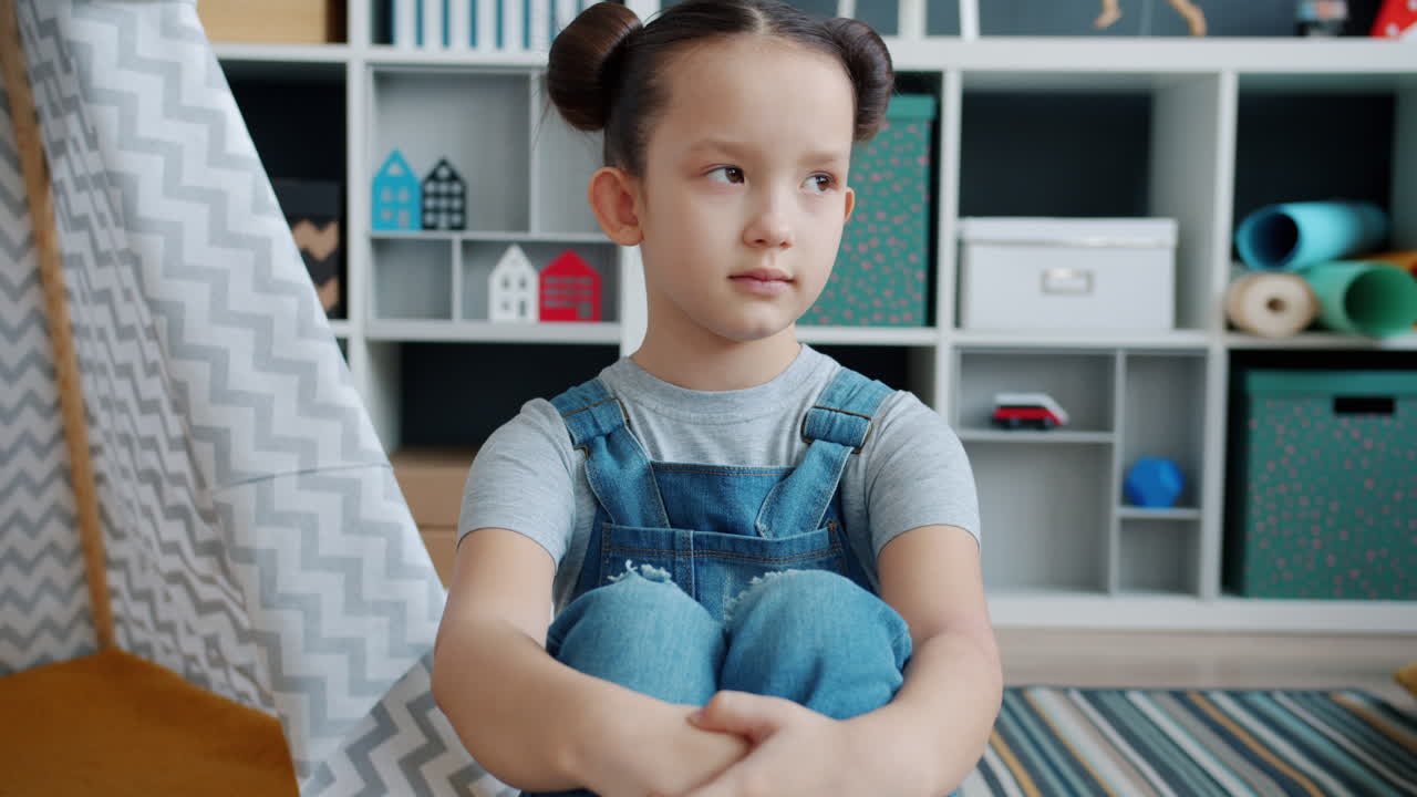 Ragazza triste seduta nella stanza dei giochi