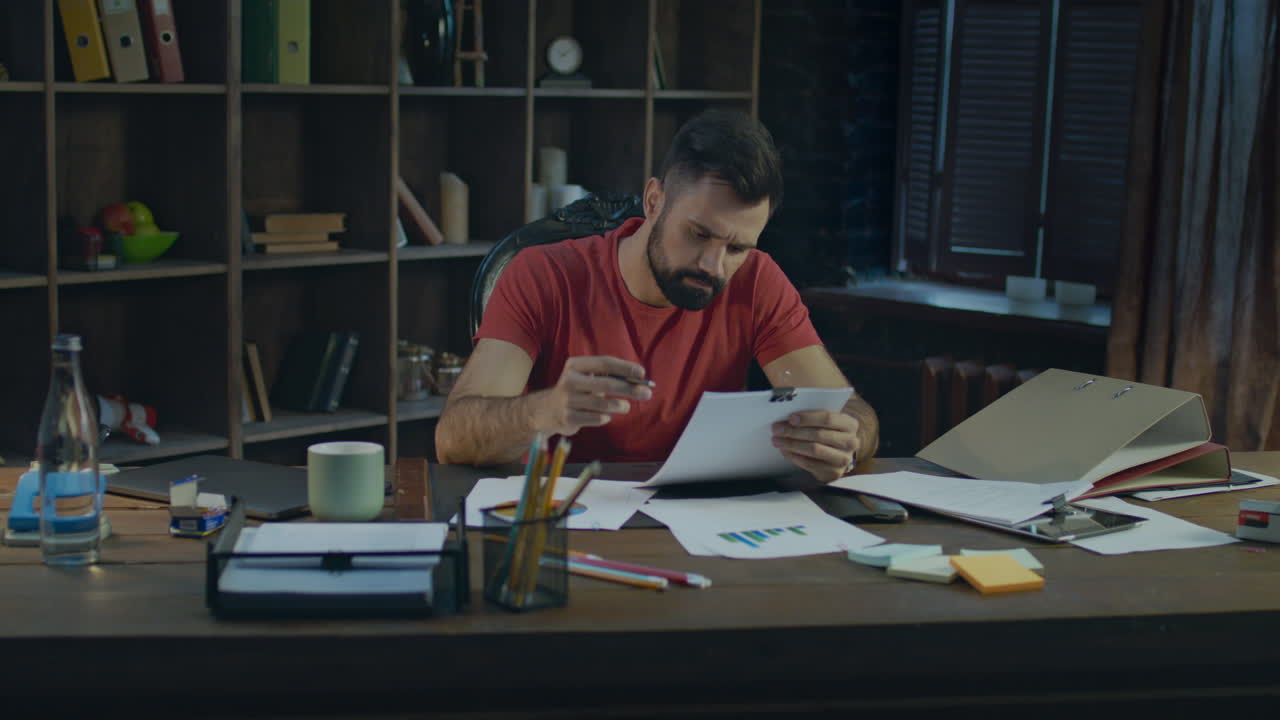 Young businessman working in cozy office. Paperwork at creative office
