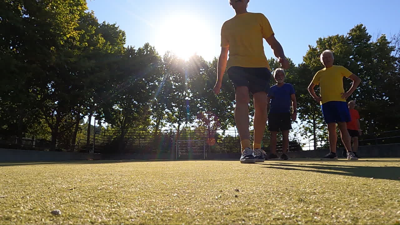 야외에서 친구들과 축구를 하면서 페널티 킥을 하는 선임 축구 선수