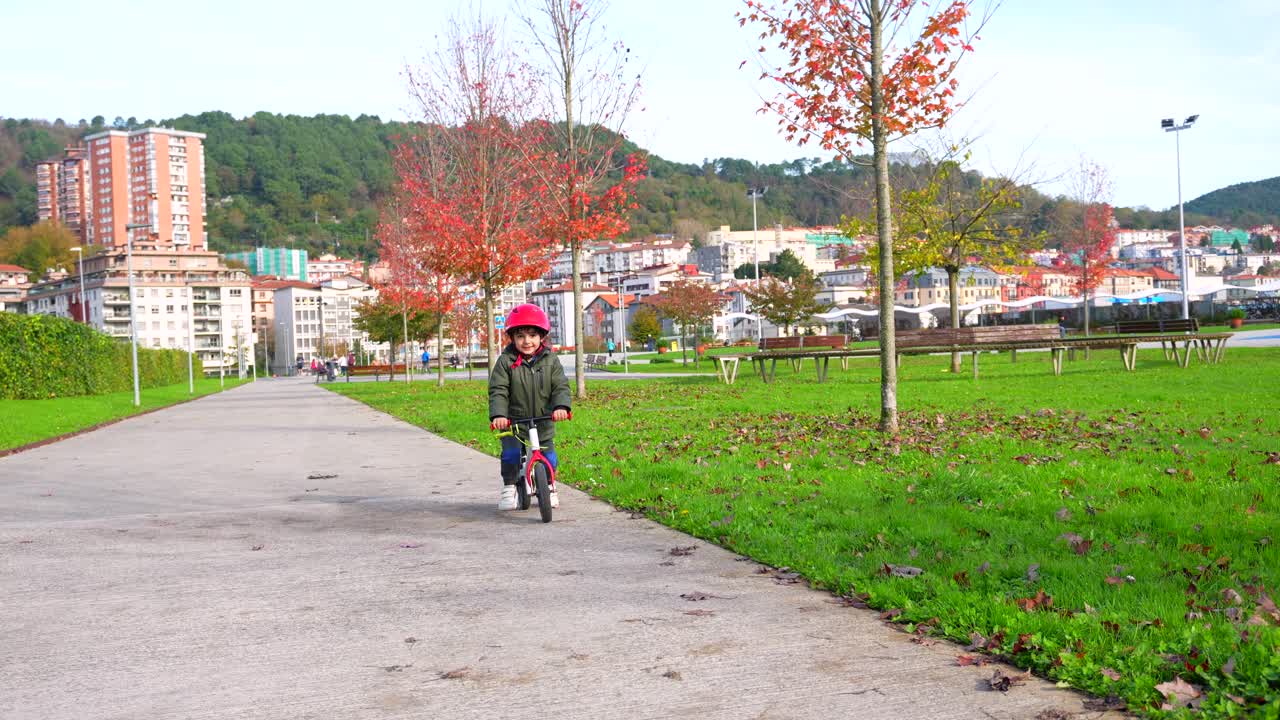 A Young Boy Riding a Balance Bike in a Park