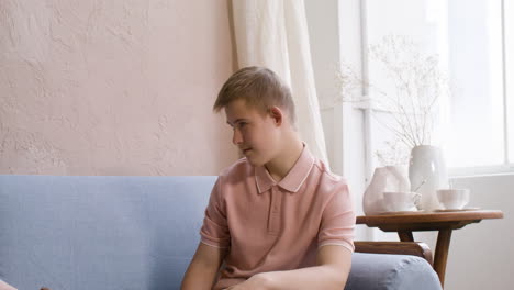 Boy-with-down-syndrome-and-his-mother-playing-with-wooden-cubes-on-the-sofa-in-the-living-room-at-home