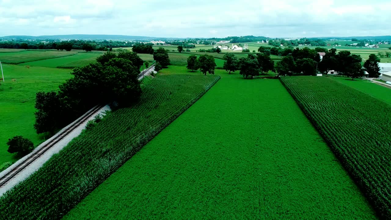 vías de tren en el campo amish y tierras de cultivo vistas por drones
