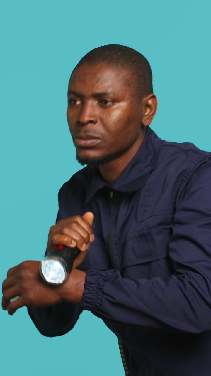 Focused Man Searching with Flashlight on Blue Background