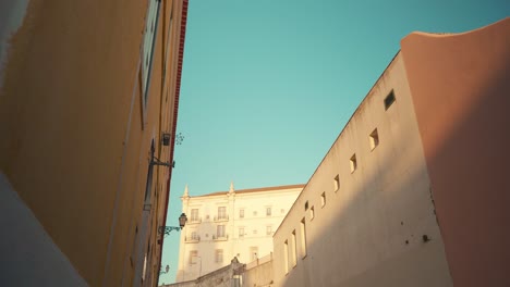 Lisbon-Alfama-ancient-typical-facade-buildings-reveal-cathedral-convent-church-at-sunrise-4K