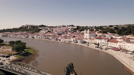 puente alcacer do sal contra el paisaje urbano ribereño, portugal, volar sobre el río sado