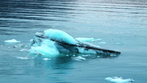 small iceberg recently calved from glacier in blue water