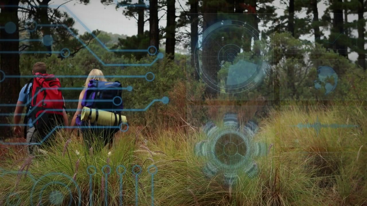 Escursionisti, uomo e donna, che camminano sull'erba, causando una sovrapposizione radar HUD tecnologica blu che li guida verso gli alberi.