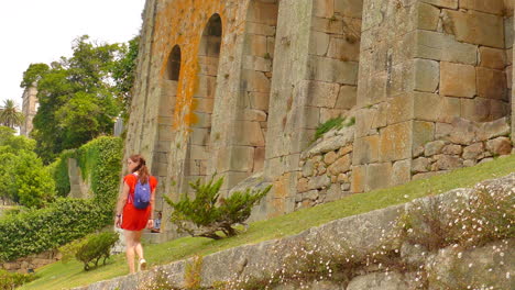 Low-angle-shot-of-a-woman-wearing-orange-dress-appreciating-of-Parque-de-las-Virtudes,-Porto,-Portugal-on-a-cloudy-day