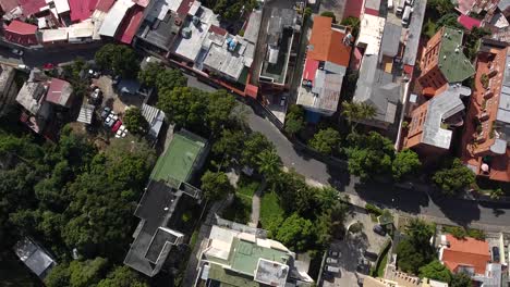 top down shot over popular neighbourhood in caracas, venezuela during the quarantine. sunlit, colourful rooftops and trees the city.