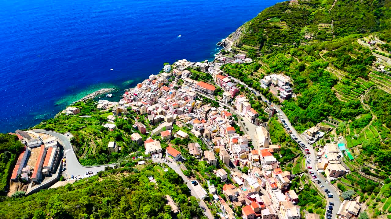 Discover a charming coastal village nestled along the Mediterranean Sea, showcasing delightful homes and lush greenery under clear blue skies