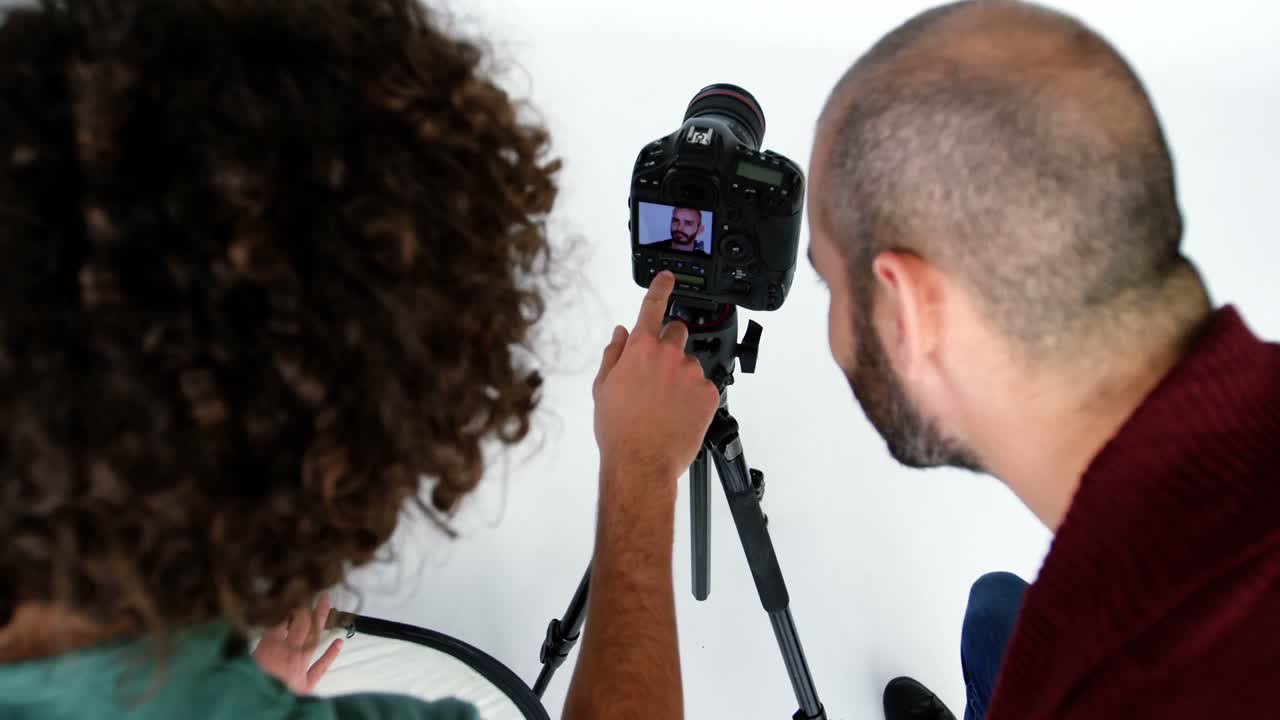 fotógrafo mostrando fotos a un modelo de moda