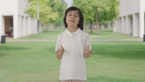 Happy-Indian-boy-talking-to-the-camera-in-park