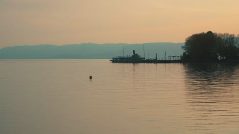 Silueta-Del-Ferry-Que-Atraca-En-El-Puerto-Del-Lago-Geneve,-Yendo-De-Francia-A-Lausana,-Suiza