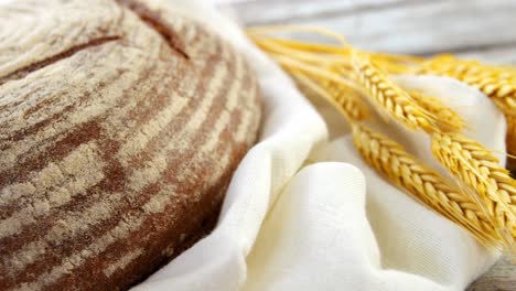 sourdough with wheat grains on wooden table