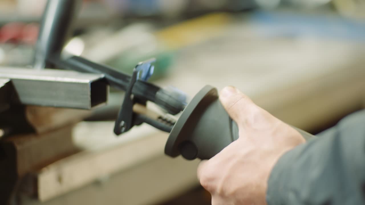 trabajador de la industria de piezas metálicas con sierra eléctrica