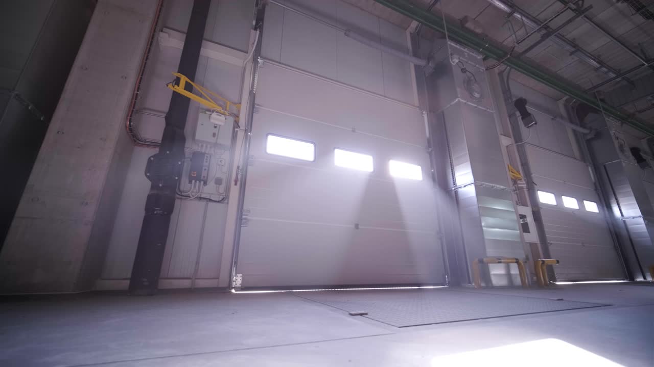 proceso de construcción de un gran almacén moderno con múltiples puertas de garaje para un fácil acceso y transporte de mercancías.