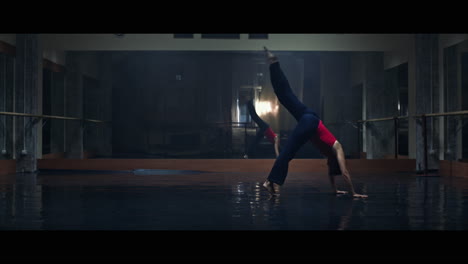 a young woman practices modern dancing and ballet in a moody room full of mirrors