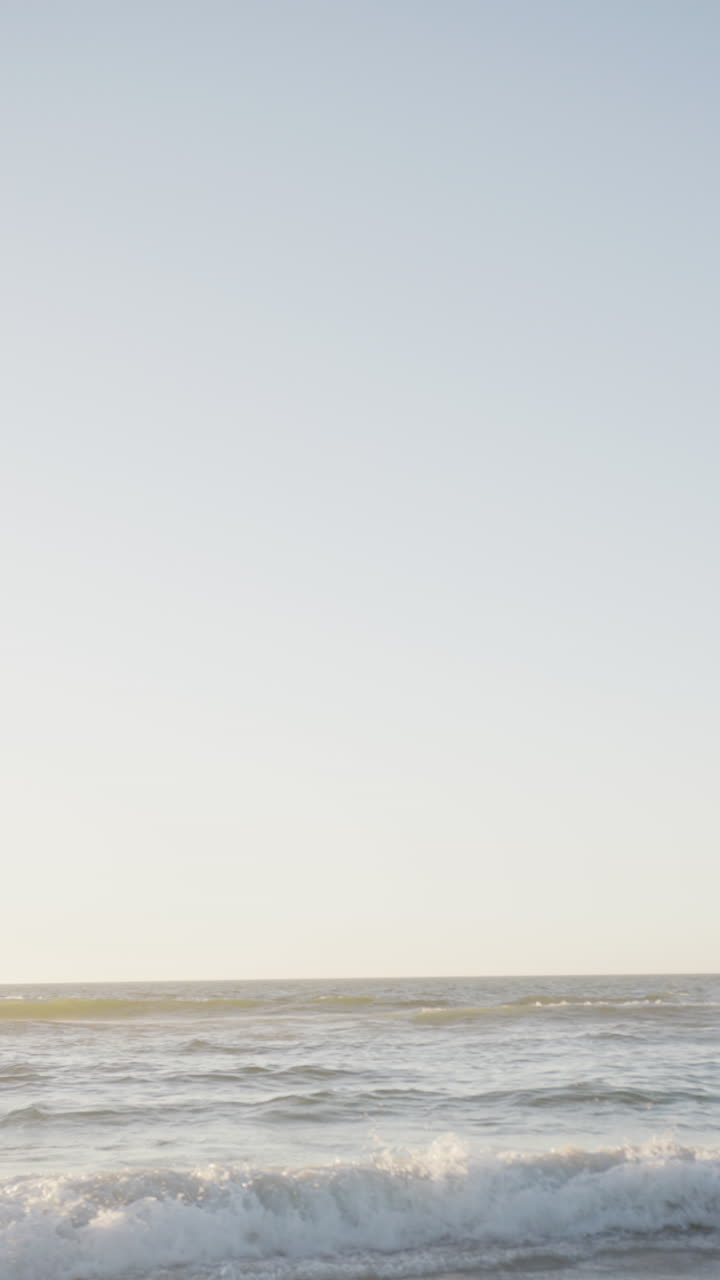 Vertical video of sea and blue sky, in slow motion, with copy space