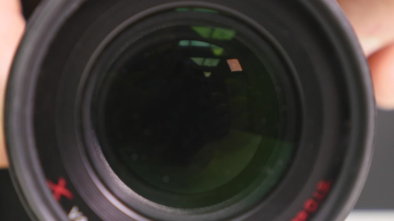 Camera zoom. Closeup shot of professional video camera, with its lens zooming in and out