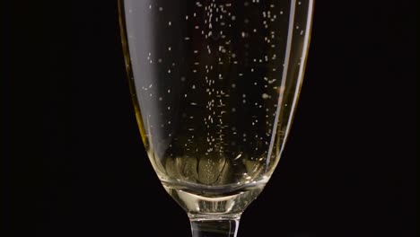 champagne bubbles rotating inside wine glass a closeup shot of a champagnefilled flute glass with bubbles rotating inside in slow motion against a dark background