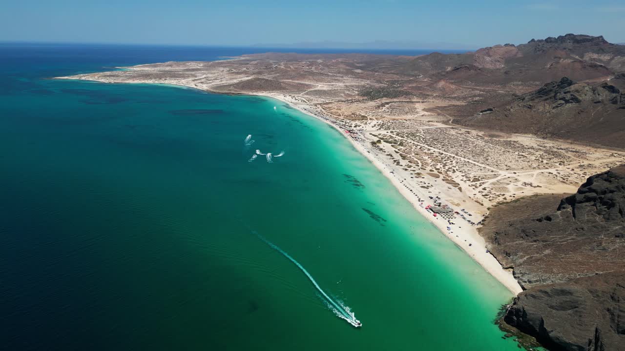 Tranquil aerial view of a pristine beach with clear water and distant rocky terrain in La Paz, Mexico