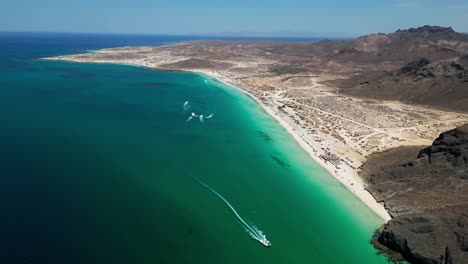 tranquil aerial view of a pristine beach with clear water and distant rocky terrain in la paz, mexico