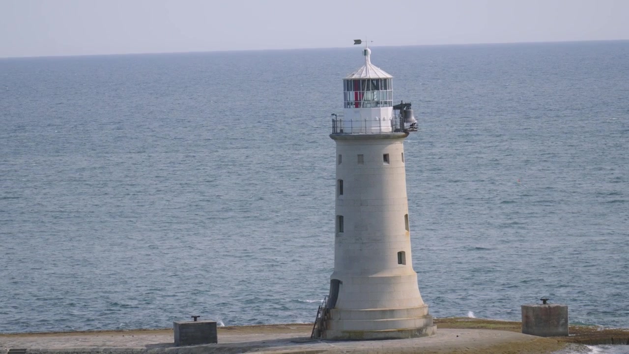 Faro di Plymouth Breakwater con mare calmo. Costa del South Devon, Regno Unito.