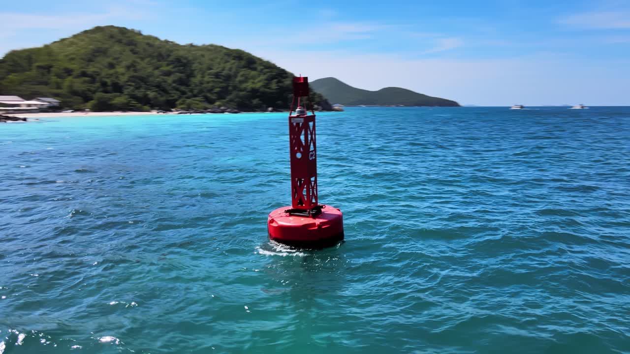 imágenes aéreas de drones de 4k que rodean una boya roja que se balancea en las olas cerca de la costa del exótico resort de ko larn, tailandia