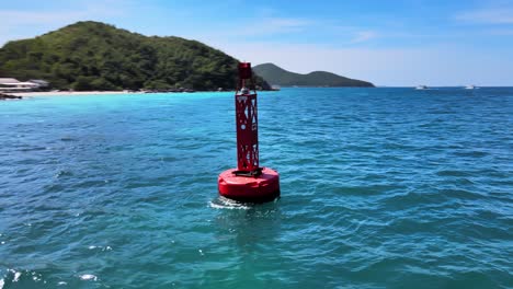 4K-Drohnenaufnahmen-Aus-Der-Luft,-Die-Eine-Rote-Boje-Umkreisen,-Die-In-Den-Wellen-Nahe-Der-Küste-Des-Exotischen-Ferienortes-Ko-Larn,-Thailand,-Schaukelt