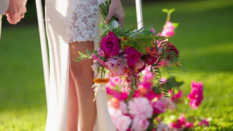 close up colorful pink wedding bouquet being held by bride walking, 4k