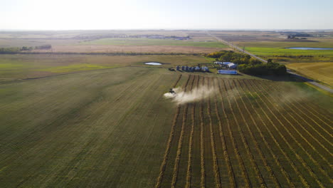 High-wide-angle-aerial-over-combine-harvester-in-farm-land-harvesting,-Alberta