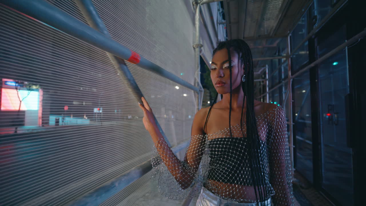magnífica mujer caminando por la noche retrato de la ciudad modelo tocando construcción de hierro