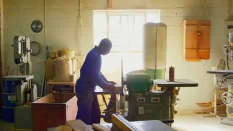 male worker cutting wooden block in workshop 4k