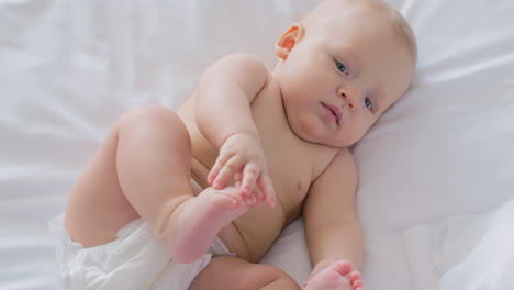 una hermosa niña de seis meses en pañal