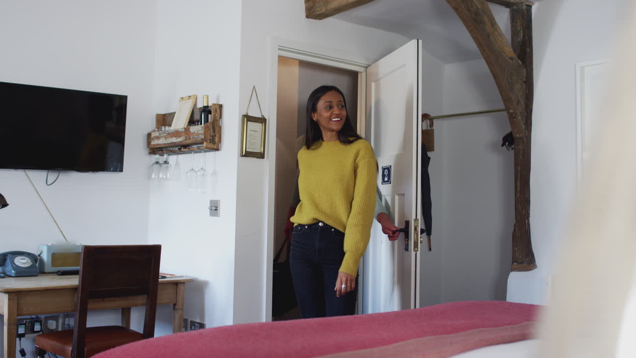 pareja pasando un fin de semana romántico lejos abriendo la puerta de la habitación del hotel y abrazándose