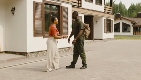 pareja amorosa abrazándose y despidiéndose fuera de casa antes de que el hombre vaya al servicio militar