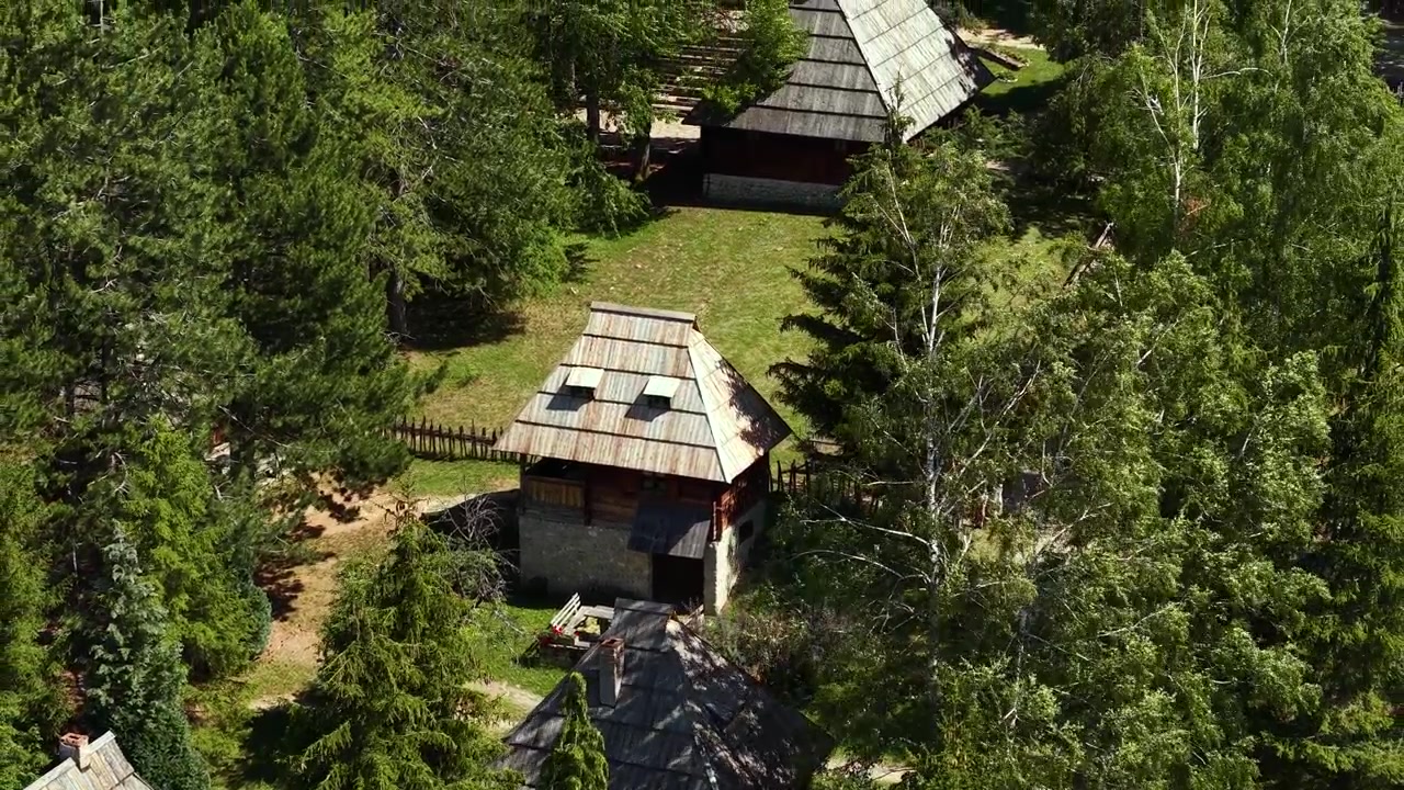 Droneoptagelse af gamle huse i Sirogojno Etnolandsby i Serbien. Traditionelle hjem på frilandsmuseum på en solrig sommerdag.
