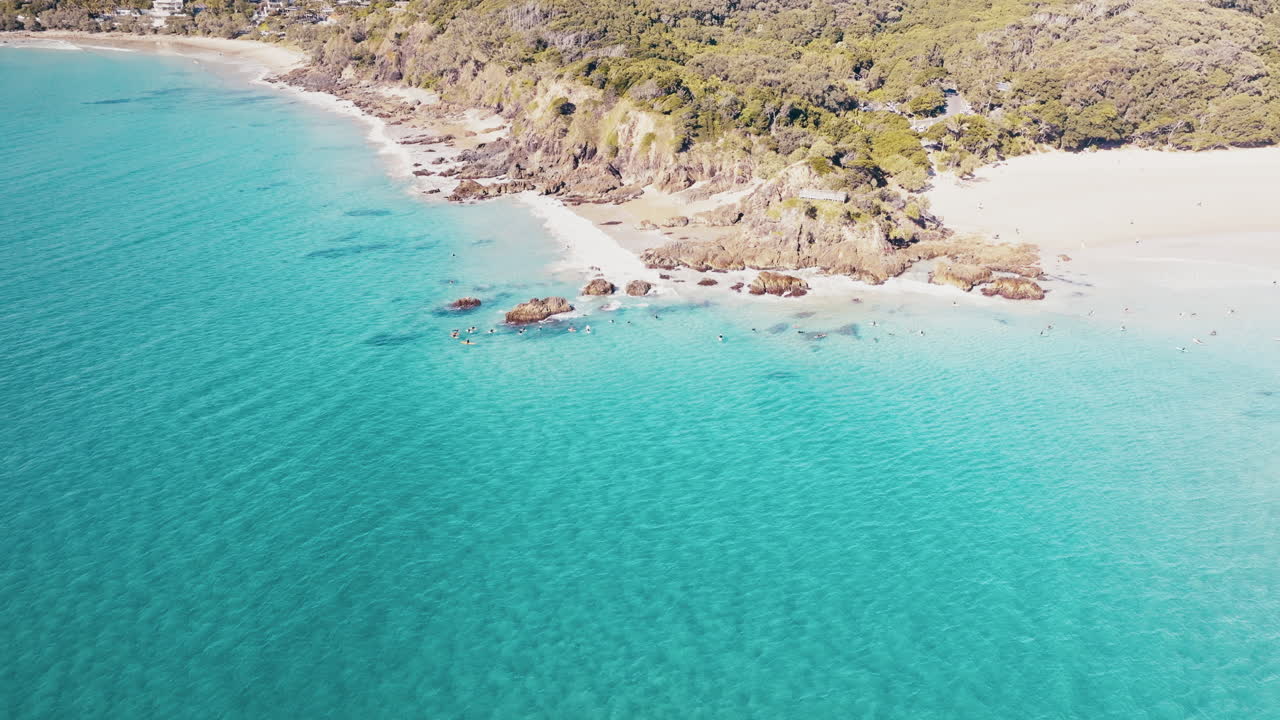 Volo di drone sopra una baia turchese e un promontorio scosceso