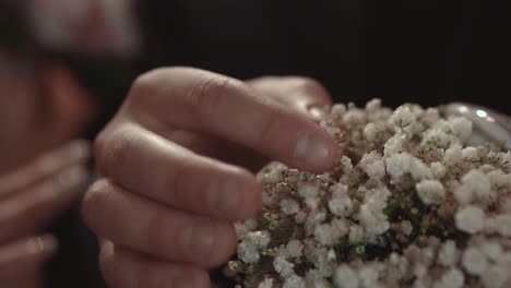 el novio toma un anillo de compromiso acostado en flores durante una ceremonia de boda en close-up en cámara lenta
