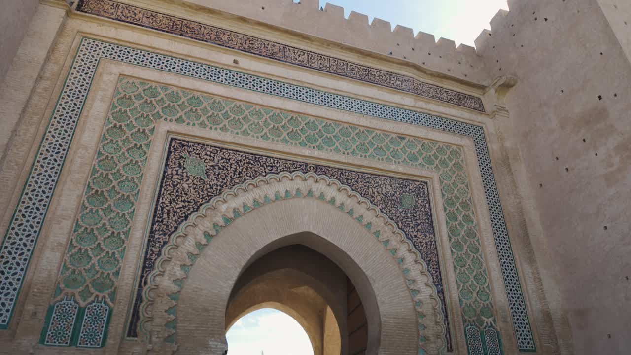 Historic stone gateway in Meknes, Morocco, featuring intricate Islamic architecture and decorative arches, establishing
