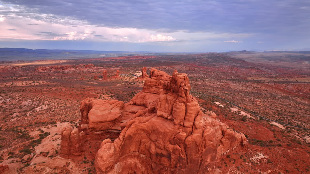 Flyver tættere på rød utilnærmelig klippe i den tørre ørken. Gråt skydække dækker himlen over Arches National Park, Utah, USA