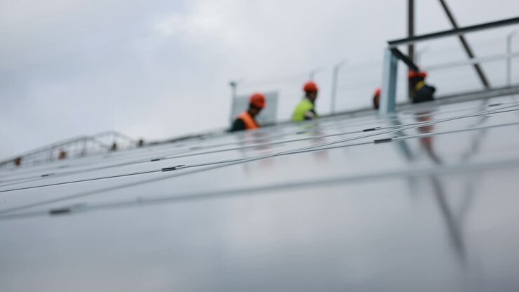 Solpaneltekniker på paneler. VINNITSA, UKRAINE - NOVEMBER 2017: Tekniker installerer nye generationers fotovoltaiske solpaneler.