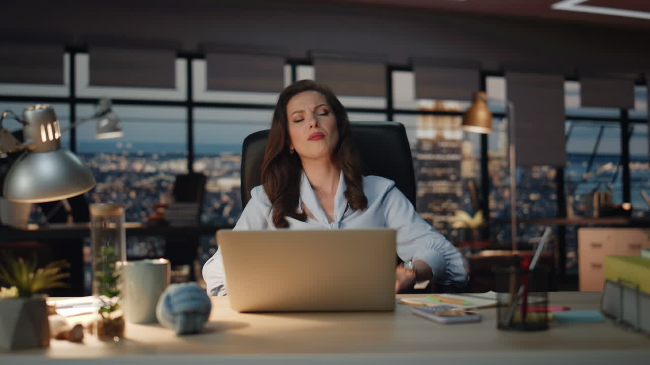 Donna turbata che reagisce a un fallimento in una postazione di lavoro con vista notturna sulla città. Perdente arrabbiato che gesticola con le mani